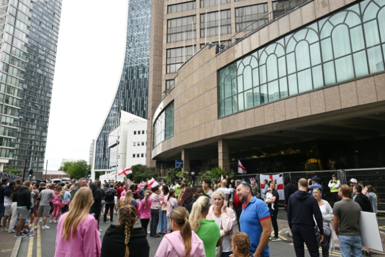 Des manifestants rassemblés devant l'hôtel Britannia qui héberge des demandeurs d'asile à Canary Wharf, le 3 août 2025 à Londres ( AFP / JUSTIN TALLIS )