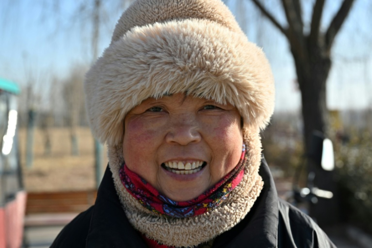 Une habitante de la ville chinoise de Baoding, dans le district de Xushui à une centaine de kilomètres de Pékin, où les autorités ont ordonné  de remplacer les poêles à charbon par des systèmes électriques ou au gaz, le 7 janvier 2026 ( AFP / Adek BERRY )