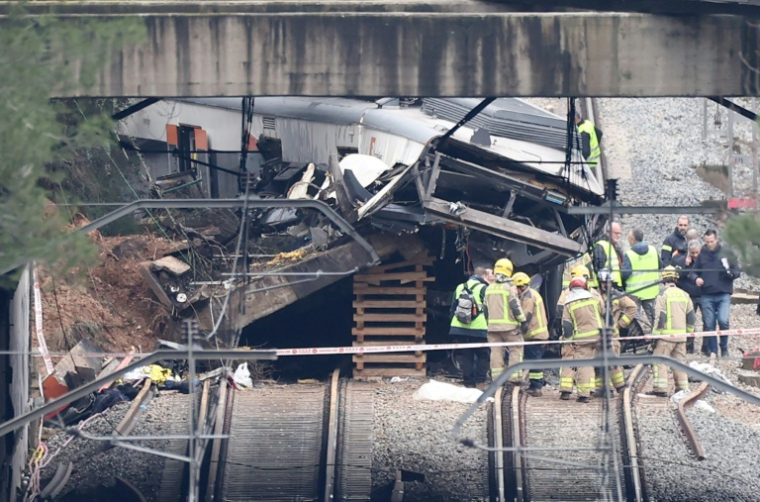 Des équipes de secours sur le site où un train de banlieue a percuté un mur de soutènement tombé sur les voies, le 21 janvier 2026 entre Sant Sadurni d'Anoia et Gelida, près de Barcelone, en Catalogne ( AFP / Josep LAGO )
