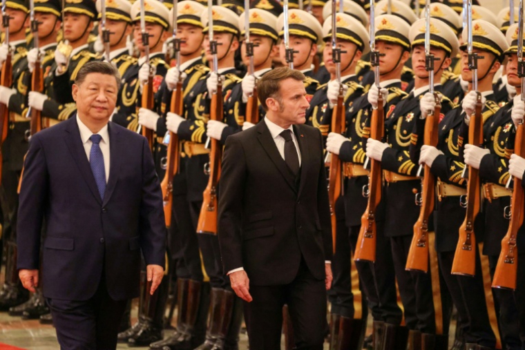 Le président chinois Xi Jinping (à gauche) et le président français Emmanuel Macron (à droite) passent en revue la garde d'honneur lors d'une cérémonie de bienvenue au Palais du Peuple à Pékin, le 4 décembre 2025 ( POOL / Ludovic MARIN )