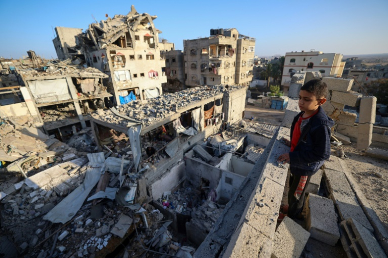 Un garçon rpalestinien regarde les décombres des bâtiments détruits dans une frappe israélienne à Bureij, dans le centre de la bande de Gaza, le 20 octobre 2025 ( AFP / Eyad BABA )
