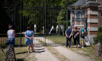 Des gens déposent des fleurs à l'entrée de la propriété de Delon, La Brulerie à Douchy, dans le centre de la France, le 18 août 2025 ( AFP / GUILLAUME SOUVANT )