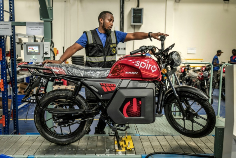 Un ouvrier inspecte une moto électrique sur une chaîne de montage du centre de production de Spiro, la plus grande entreprise de véhicules électriques d'Afrique, le 22 mai 2026 à Nairobi, au Kenya ( AFP / Luis TATO )