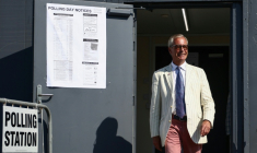 Nigel Farage, chef du parti britannique Reform UK, sort d'un bureau de vote installé dans une école primaire de Walton-on-the-Naze, dans l'Essex, lors de l'élection partielle de Clacton, le 13 août 2026 ( AFP / Henry NICHOLLS )