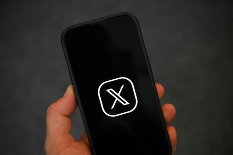 Logo du réseau social X sur un smartphone  ( AFP / Nicolas TUCAT )