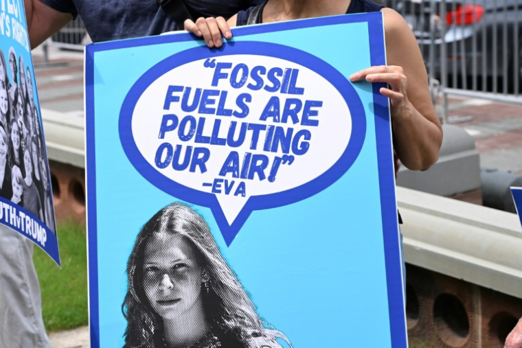 Une banderole avec une citation d'Eva Lighthiser, à la tête d'un combat judiciaire contre la politique du président américain Donald Trump favorable aux énergies fossiles, lors d'une manifestation devant le Congrès, à Washington, le 16 juillet 2025 ( AFP / Alex WROBLEWSKI )