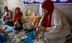 Une travailleuse sociale (d) montre à des mères comment préparer des repas nutritifs pour leurs enfants lors d'un programme de nutrition de l'Unicef au village de Fateh Muhammad Soomro, dans la province du Sindh, le 29 juillet 2025 au Pakistan ( AFP / Rizwan TABASSUM )