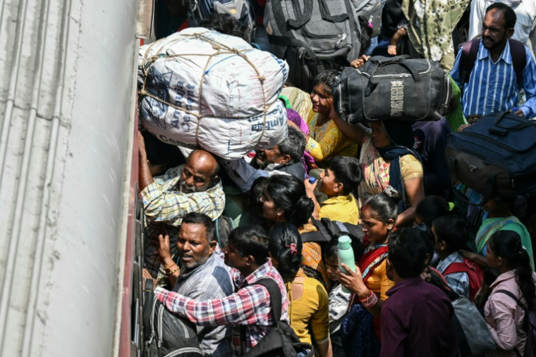 Des habitants tentent de monter dans un train à la gare de Jammu, le 10 mai 2025 au Cachemire indien ( AFP / Money SHARMA )