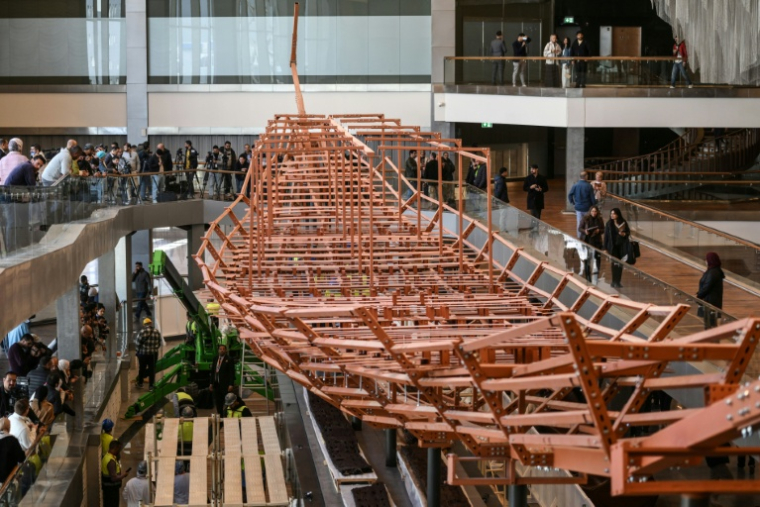Des planches de bois anciennes provenant de la deuxième barque du roi Khéops installées sur une structure métallique au Grand Musée égyptien de Gizeh, en périphérie du Caire, le 23 décembre 2025 ( AFP / Ahmed HASAN )