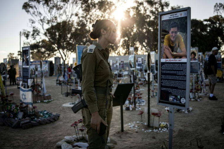 Une soldate israélienne se recueille au mémorial des victimes de l'attaque du Hamas à Réïm, dans le sud d'Israël, le 7 octobre 2025, jour du deuxième anniversaire de l'attaque ( AFP / JOHN WESSELS )