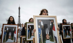 Des militants de l'association Action non violente - Cop21 (ANV-Cop21) tiennent des portraits à l'envers du président Emmanuel Macron décrochés dans différentes mairies, le 8 décembre 2019 sur l'esplanade du Trocadéro, à Paris ( AFP / Thomas SAMSON )