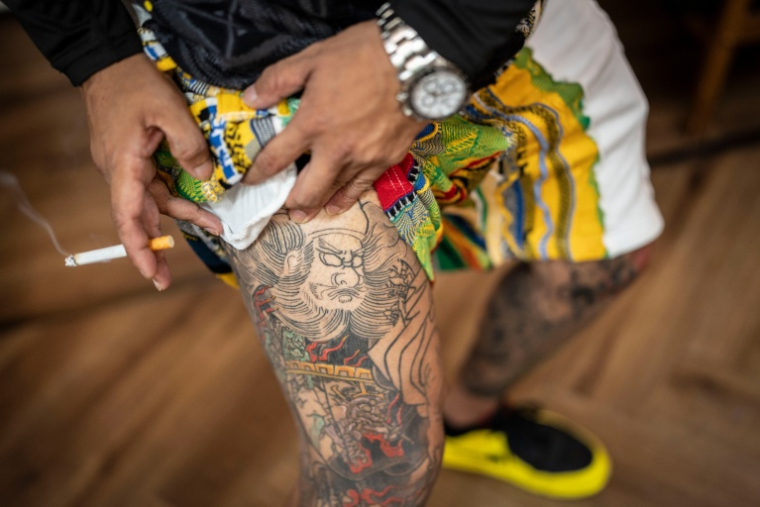 Le yakuza Tekisasu montrant ses tatouages, dans un barbershop de Tokyo au Japon, le 27 août 2026 ( AFP / Yuichi YAMAZAKI )