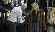 Le propriétaire du magasin de fourrures Madison Avenue Furs à New York, Larry Cowit, avec une cliente, le 10 mars 2026 ( AFP / ANGELA WEISS )