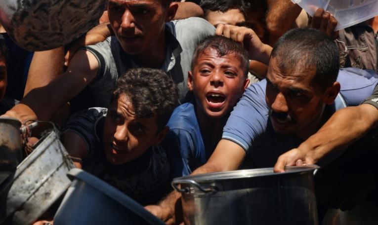 Des Palestiniens se bousculent pour recevoir des portions de nourriture d'une organisation de charité locale à Khan Younès, dans le sud de la bande de Gaza, le 27 août 2025 ( AFP / - )