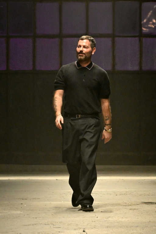 Le créateur de mode italien Fausto Puglisi salue le public à la fin du défilé Cavalli, présenté dans le cadre de la collection automne-hiver 2026-2027 de la Fashion Week de Milan, le 26 février 2025 ( AFP / Andreas SOLARO )