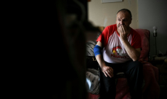 Maurice, 67 ans, dans son appartement à Colombes (Hauts-de-Seine) à l'occasion d'une visite d'un bénévole de l'association Petits frères des pauvres, le 5 août 2026 ( AFP / Lou BENOIST )