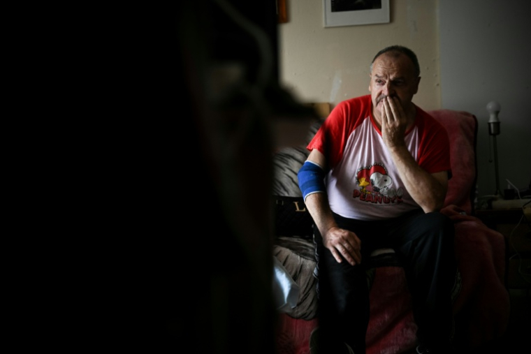 Maurice, 67 ans, dans son appartement à Colombes (Hauts-de-Seine) à l'occasion d'une visite d'un bénévole de l'association Petits frères des pauvres, le 5 août 2026 ( AFP / Lou BENOIST )