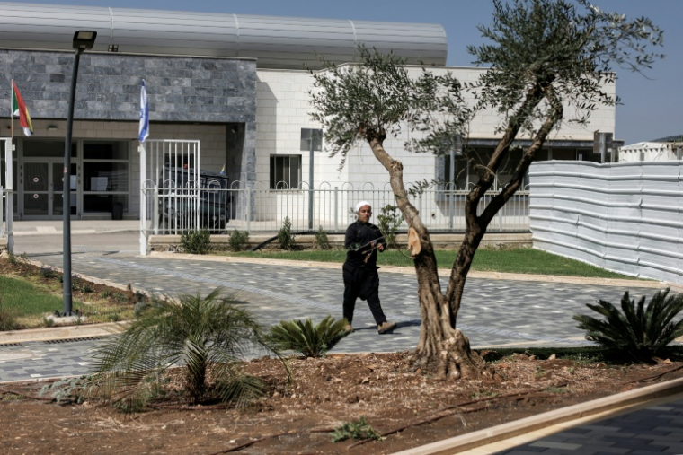 Un jeune druze devant la nouvelle école du village d’Ein Qiniyye, sur le plateau du Golan annexé par Israël, le 4 octobre 2026 ( AFP / Jalaa MAREY )