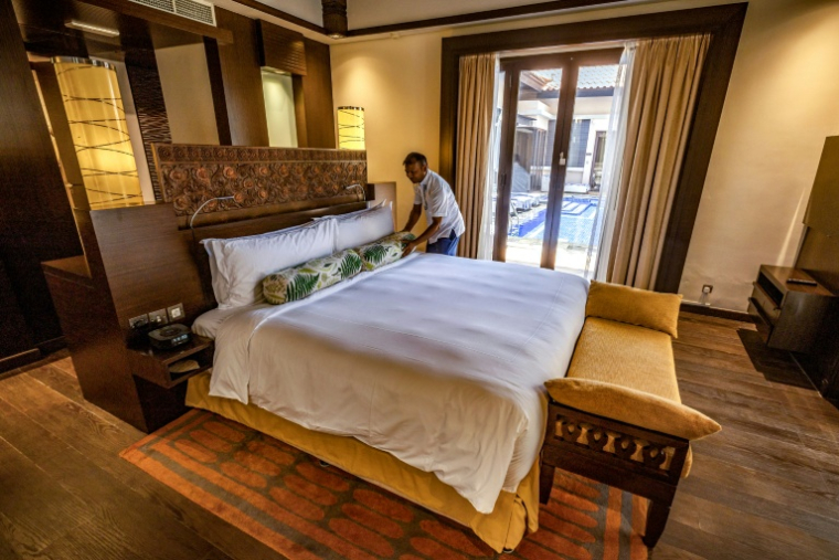 Un employé fait le lit d'une chambre de l'hôtel Anantara The Palm à Dubaï, le 6 juin 2026 ( AFP / FADEL SENNA )