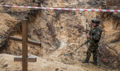Un militaire ukrainien inspecte un charnier sur le site d'un cimetière improvisé de civils et de soldats ukrainiens dans la ville d'Izioum