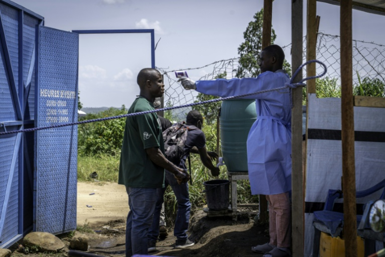 Un agent de santé prend la température d'un visiteur à l'hôpital de Rwampara, dans le nord-est de la République démocratique du Congo (RDC) le 26 mai 2026 ( AFP / Glody MURHABAZI )