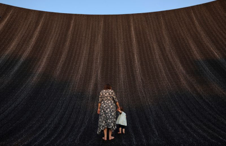 Une femme tient la main d'un bébé alors qu'ils profitent tous deux de la cascade de l'Expo à la COP28, à Dubaï