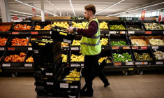 Un employé organise des produits dans un supermarché à Richmond, Londres