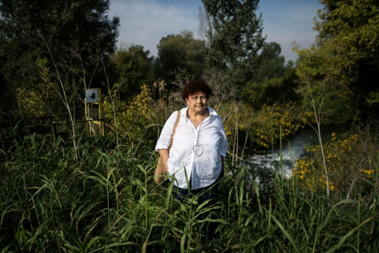 Nicoletta Mensi, membre de l'association "Ce l’ho nel sangue" ("C’est dans mon sang") pose près d'un conduit de rejet d'eau dans la rivière Bormida à Spinetta Marengo, dans le nord de l'Italie, le 29 septembre 2026 ( AFP / Marco Bertorello )