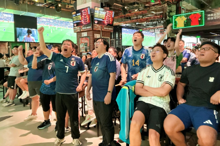 Des supporters chinois de l'équipe du Japon de football en train de suivre la rencontre du groupe F de la Coupe du monde 2026 entre le Japon et la Tunisie, à Shanghai, le 21 juin 2026 ( AFP / Rebecca BAILEY )