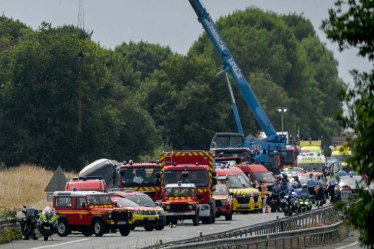 Une grue soulève un autocar accidenté sur l'autoroute A81, à Degré, dans la Sarthe, le 13 juin 2025 ( AFP / JEAN-FRANCOIS MONIER )