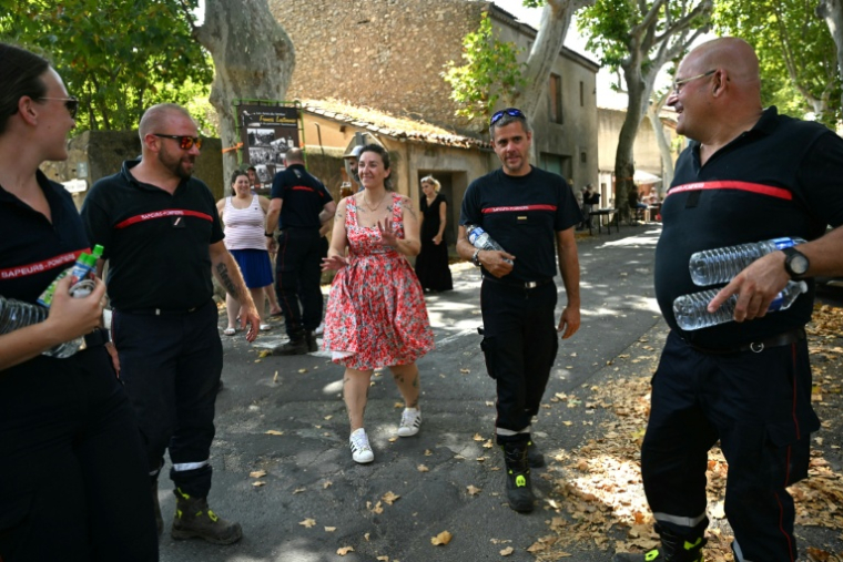 Une femme remercie les pompiers pour leur lutte contre les incendies à Tournissan, dans le sud de la France, le 10 août 2025 ( AFP / Bertrand GUAY )