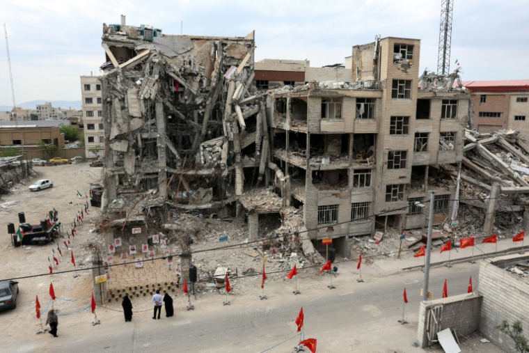 Des habitants devant un immeuble résidentiel détruit par une frappe aérienne américano-israélienne à Téhéran, le 13 avril 2026 ( AFP / - )
