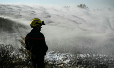 Les pompiers éteignent des cendres chaudes à côté d'Albas, dans le massif des Corbières, le 9 août ( AFP / Bertrand GUAY )