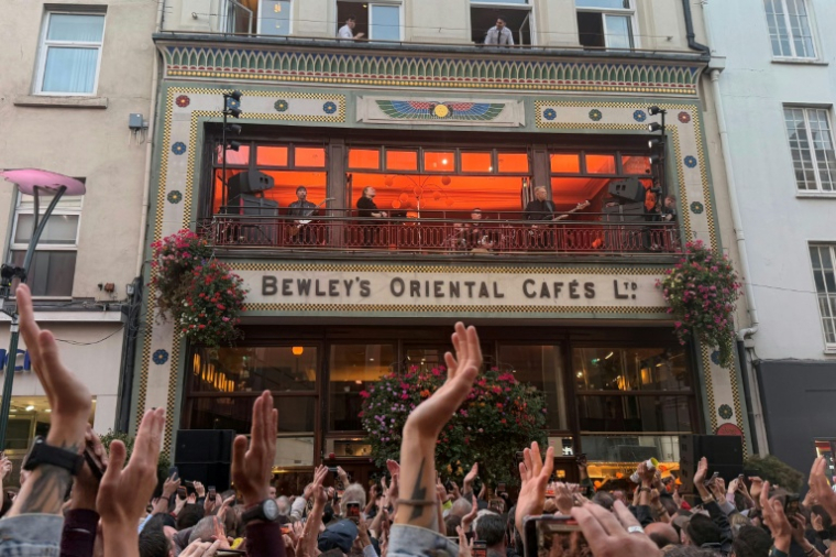Le groupe de rock irlandais U2 lors d'un concert surprise au balcon du Bewley's Oriental Cafe dans le centre de Dublin, le 25 septembre 2026 ( AFP / Peter MURPHY )