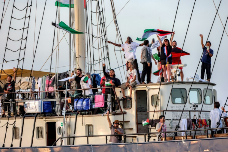 Des militants et défenseurs des droits humains à bord d'un navire quittent le port de Bizerte, au nord de la Tunisie, le 14 septembre 2025, pour rejoindre les derniers bateaux participant à la flottille mondiale Sumud, à destination de la bande de Gaza pour briser le blocus israélien sur le territoire palestinien ( AFP / Mohamed FLISS )