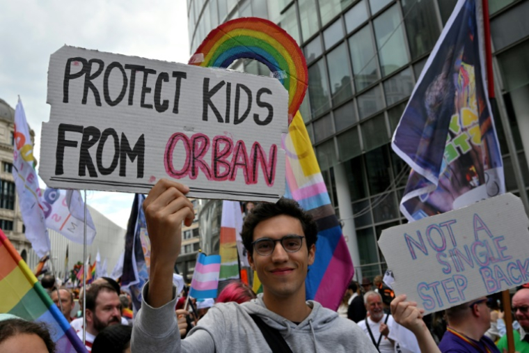 Un manifestant tient une pancarte "protégez les enfants d'Orban", lors de la marche des fiertés à Bruxelles, le 17 mai 2025 ( AFP / Nicolas TUCAT )