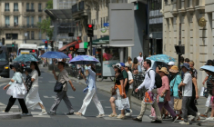 Des touristes se protègent du soleil sous des parapluies à Paris le 23 juin 2026 ( AFP / Thomas SAMSON )