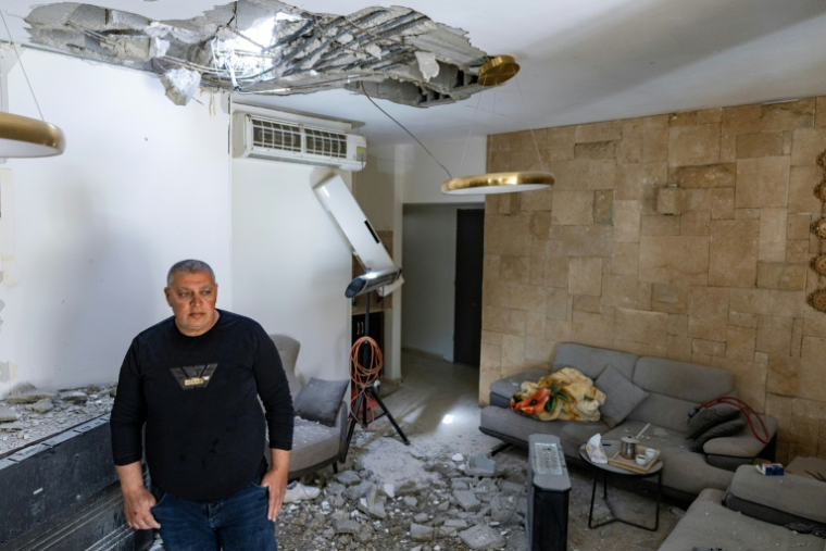 Khalil Khalil examine les dégâts causés à sa maison à Bi'ina, près de la frontière libanaise, dans le nord d'Israël, le 12 mars 2026 ( AFP / Odd ANDERSEN )