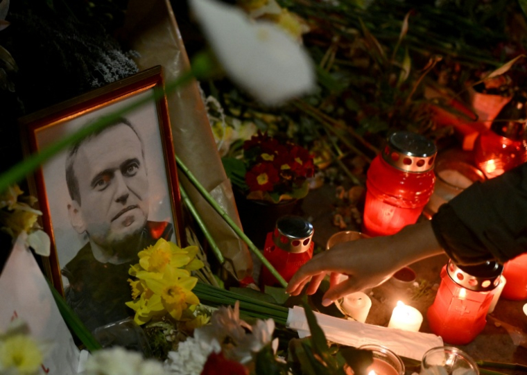 Un portrait de l'opposant russe décédé, Alexeï Navalny, entouré de fleurs et de bougies déposées en hommage devant un mémorial improvisé à Belgrade, le 1er mars 2024 ( AFP / OLIVER BUNIC )