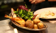 Une assiette de poulet roti au restaurant Gigi's à New York le 26 avril 2026 ( AFP / CHARLY TRIBALLEAU )