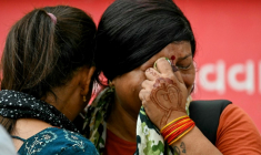 Des femmes pleurent la mort de leurs proches au lendemain du crash du vol Air India 171, à Ahmedabad le 13 juin 2025 ( AFP / Punit PARANJPE )