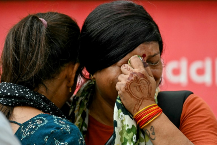Des femmes pleurent la mort de leurs proches au lendemain du crash du vol Air India 171, à Ahmedabad le 13 juin 2025 ( AFP / Punit PARANJPE )