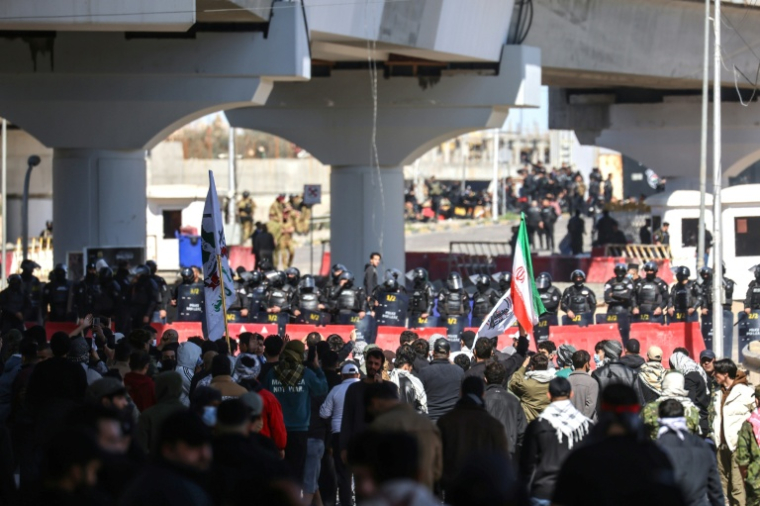Des membres des forces de sécurité irakiennes font face à des manifestants pro-Iran près de la Zone verte, où se trouve l’ambassade des États-Unis, à Bagdad, le 1er mars 2026. ( AFP / Ahmad AL-RUBAYE )