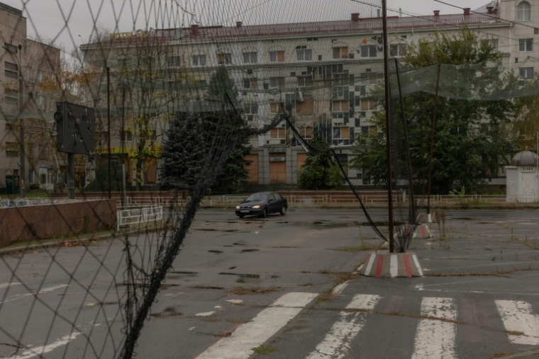 Une voiture dans une rue où des filets antidrones ont été disposés, le 30 octobre 2026 à Kherson, dans le sud de l'Ukraine  ( AFP / Roman PILIPEY )