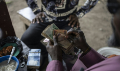 Un homme recompte ses nairas, la monnaie du Nigeria, pays frappé par une crise économique depuis deux ans, le 16 septembre 2024 à Lagos ( AFP / Olympia DE MAISMONT )