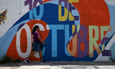 Une femme passe devant une fresque murale dans le quartier du 10 de Octubre à San Marcos, au Salvador, le 14 juin 2025 ( AFP / Marvin RECINOS )