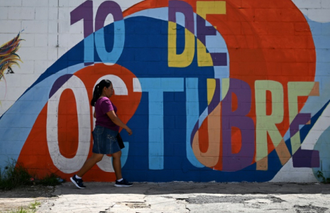 Une femme passe devant une fresque murale dans le quartier du 10 de Octubre à San Marcos, au Salvador, le 14 juin 2025 ( AFP / Marvin RECINOS )