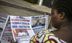 Une habitante regarde les journaux sur un étal dans une rue de Cotonou après une tentative déjouée de coup d'Etat au Bénin, le 8 décembre 2025 ( AFP / OLYMPIA DE MAISMONT )