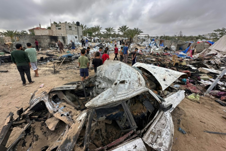Des Palestiniens au milieu des dégâts dans le camp de déplacés à Al-Mawassi visé par des frappes israéliennes, dans le sud de la bande de Gaza, le 18 mai 2025 ( AFP / - )