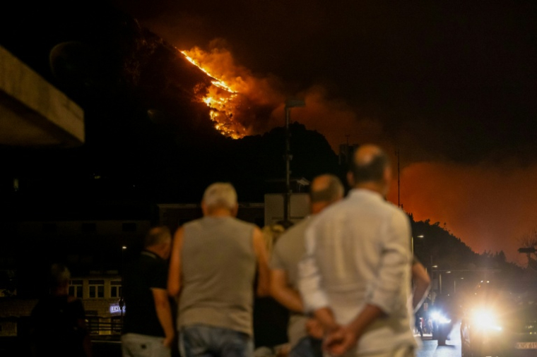 Des habitants observent un violent incendie de forêt près d'Omiš, à une trentaine de kilomètres au sud de Split, le 14 août 2026 en Croatie ( AFP / MIROSLAV LELAS )